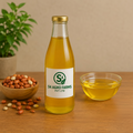 Bottle of S4 Agro Farms oil on a wooden table with groundnut seeds and a plant in the background